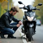Jeune homme vérifiant la pression des pneus d'un scooter Yamaha XMAX