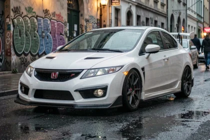 Honda Civic Type R EP3 blanche garée dans une rue urbaine humide, vue trois-quarts avant