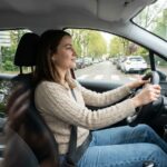 Jeune femme au volant d'une voiture en ville Rhône