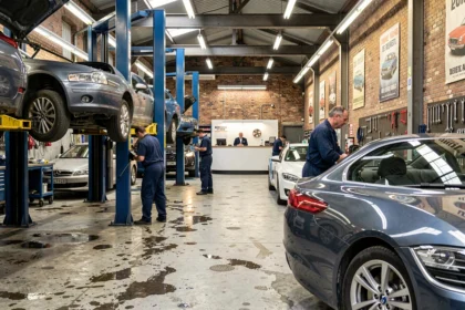 Vue panoramique d'un garage automobile parisien avec mécaniciens au travail sur plusieurs véhicules