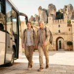 Couple descendant d'une navette touristique à l'entrée des Baux-de-Provence pour éviter la marche depuis le parking