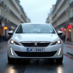 Peugeot 308 blanche garée dans une rue parisienne, vue de face en angle 3/4