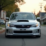 Subaru Impreza WRX argentée garée dans une rue résidentielle, vue en angle trois quarts avant avec capot prise d'air visible