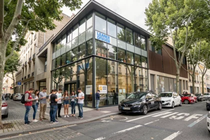 Vue d'ensemble d'une auto-école dans le Rhône avec des voitures à double commande garées devant l'établissement