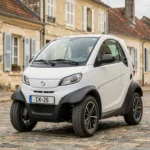 Voiture sans permis blanche garée dans une rue de Challans avec architecture vendéenne en arrière-plan