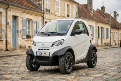 Voiture sans permis blanche garée dans une rue de Challans avec architecture vendéenne en arrière-plan
